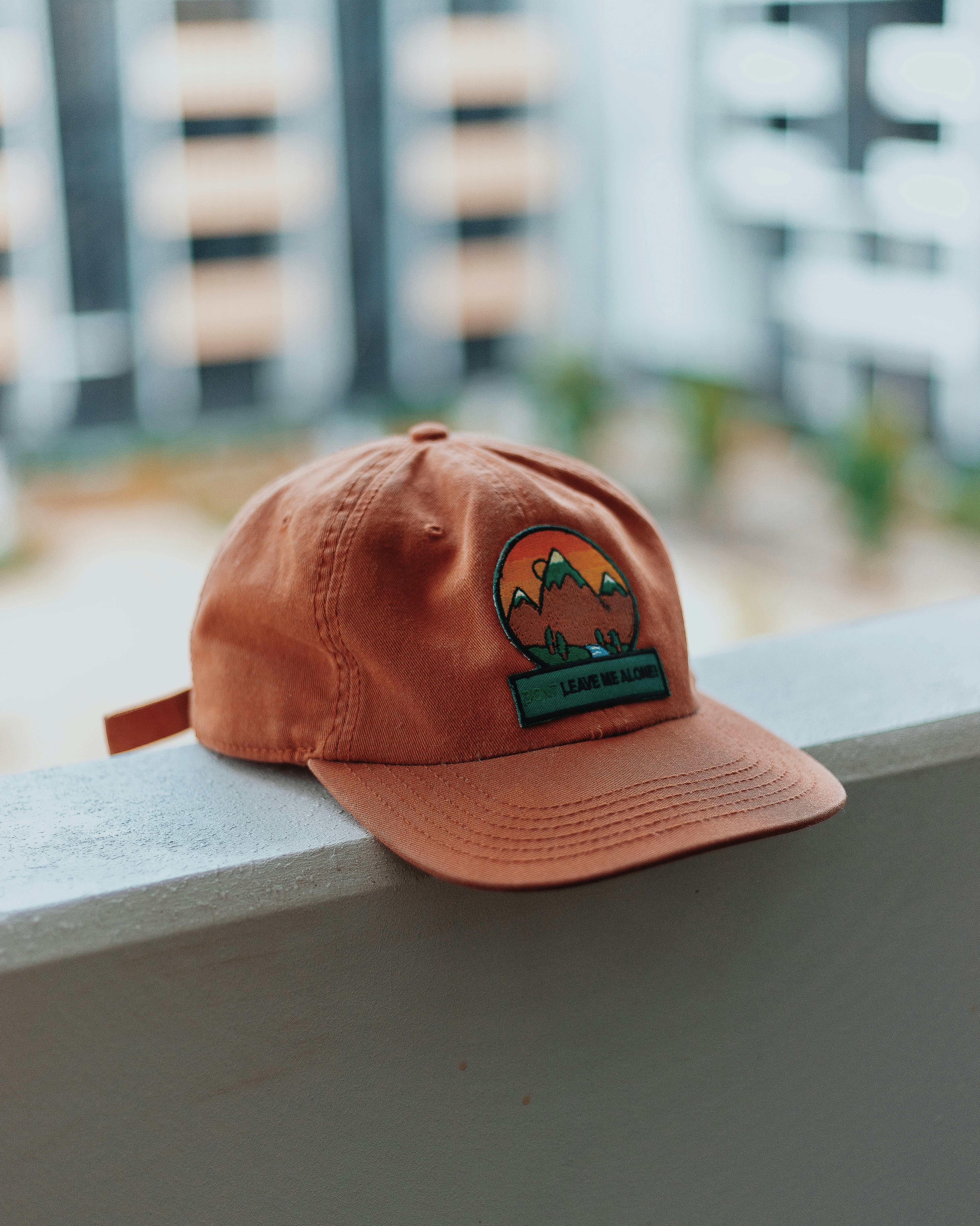 Rust-coloured cotton cap resting on a ledge